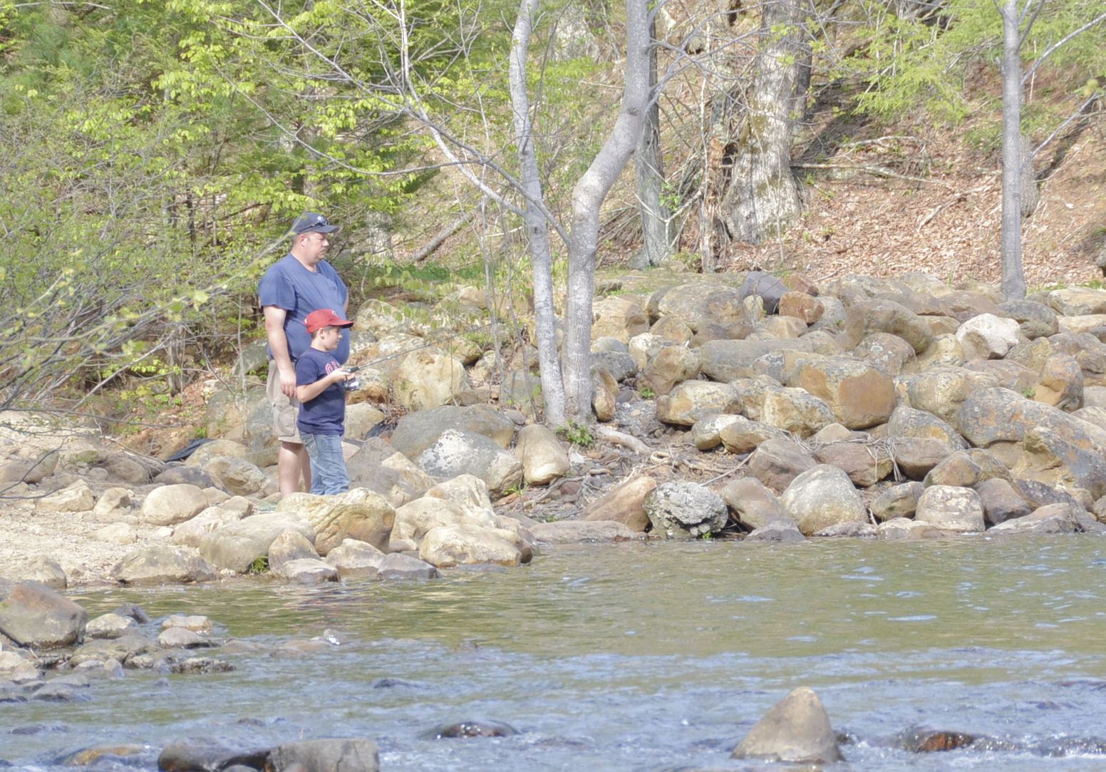 Father and son fishing near a spillway at Douthat State Park, Virginia.