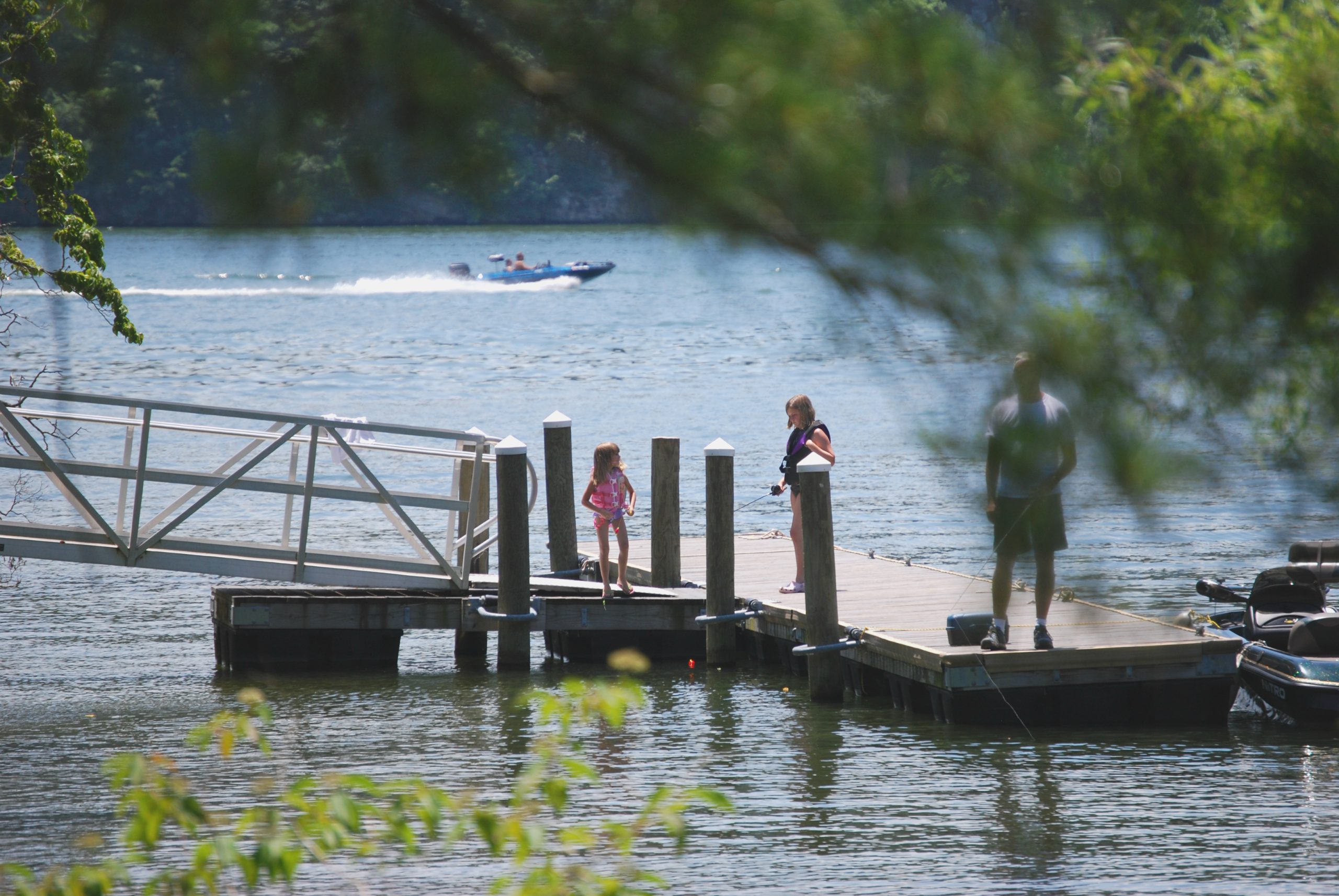 Family fishing from a dock near lodges at Claytor Lake State Park, Virginia.
