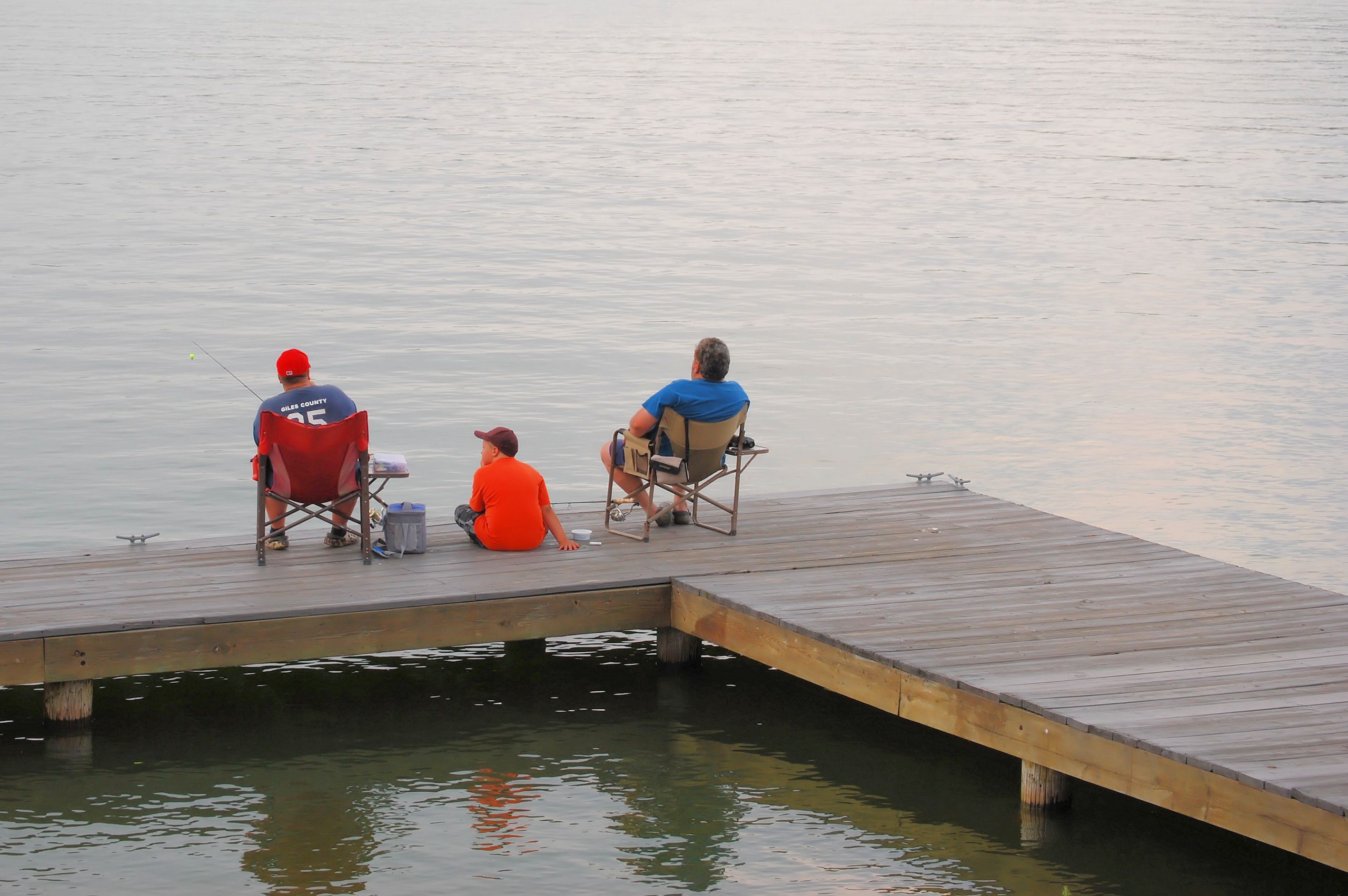 Dad, son, and grandpa fishing from a dock at Claytor Lake State Park in Virginia.